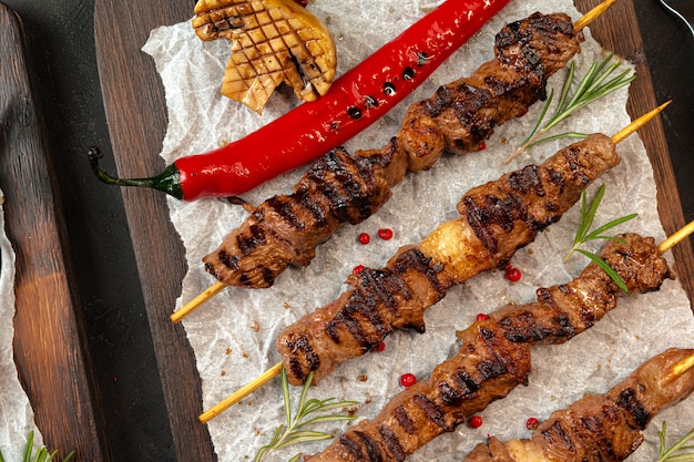Photo grilled meat skewers barbecue served on board. kebab meat