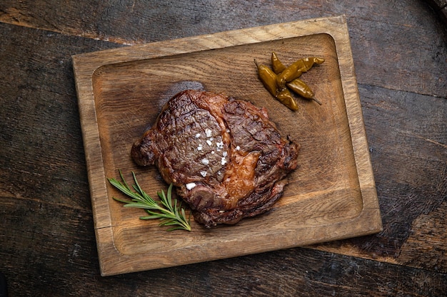 Foto bistecca di carne alla griglia su una tavola di legno con spezie in un ristorante premium