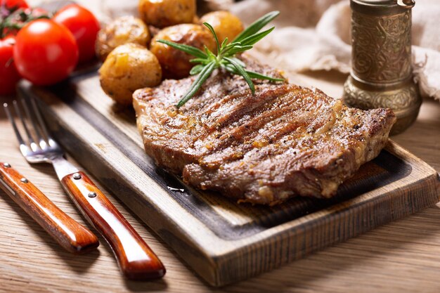 grilled meat with potatoes on a wooden board