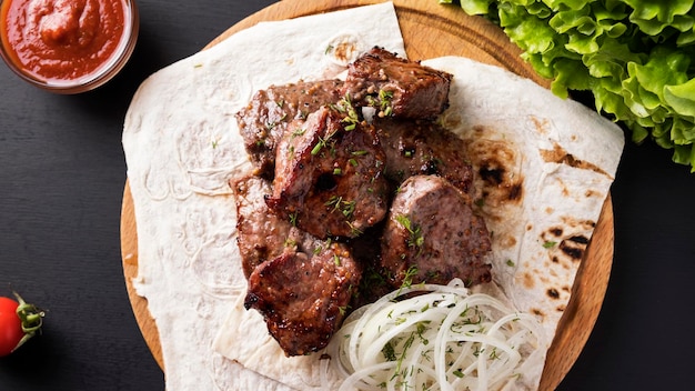 Carne alla griglia su tavola di legno. shish kebab di vitello. vista dall'alto