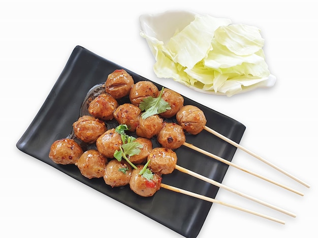 Grilled meatballs with sauce served with cabbage