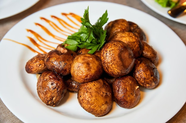 Grilled mushrooms with herbs on a white plate