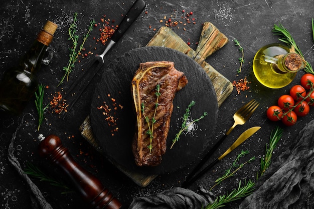 Grilled New York beef steak on the bone herbs and spices Juicy cooked steak Top view Rustic style Flat Lay