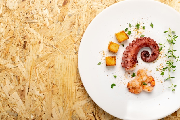 Foto polpo alla griglia sul piatto ristorante bianco servito con gamberetti