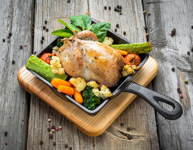 Photo grilled pheasant with bacon and spices and vegetables, on a wooden background