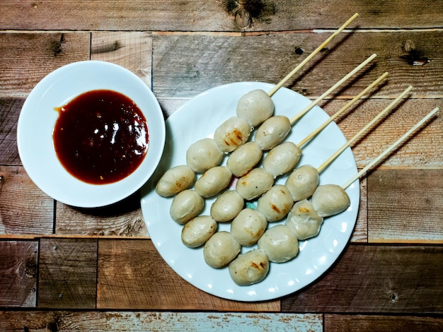 Polpette di maiale alla griglia con salsa piccante tailandese su sfondi di legno