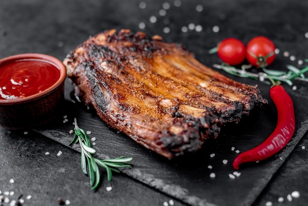 Photo grilled pork ribs on a stone background
