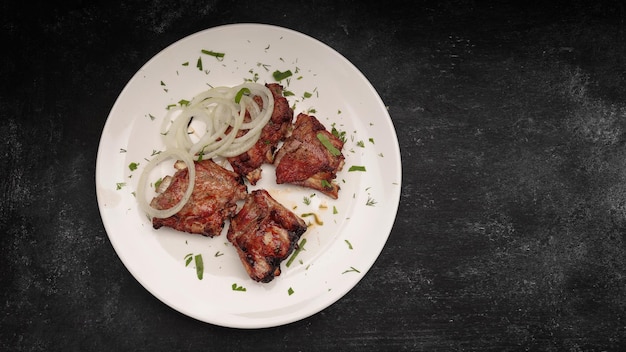 Grilled pork ribs with herbs on a dark background