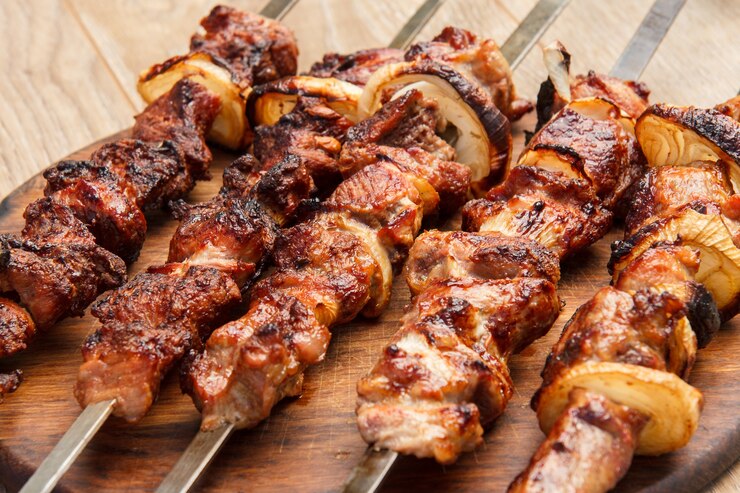 木製のまな板のグリルで焼いた串焼きの豚肉のグリル。バーベキュー、ピクニック