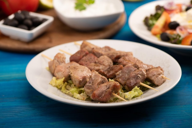 A grilled pork souvlaki served with greek salad