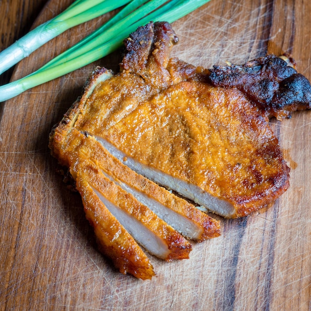 Grilled pork steak on a cutting board View from above