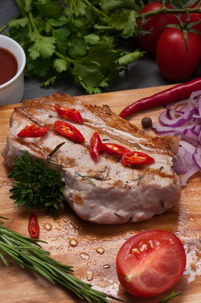 Grilled pork steak with red onion, carrot and tomato sauce