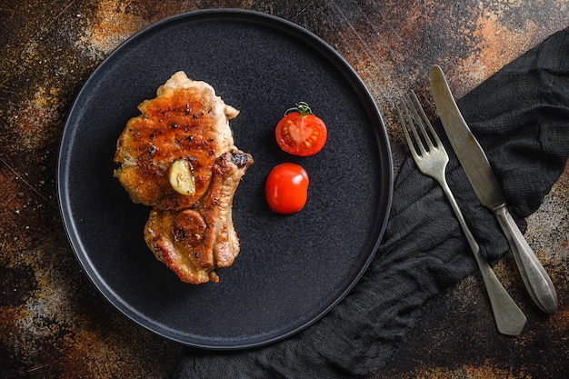 Grilled pork steak with seasonings with fork and knife