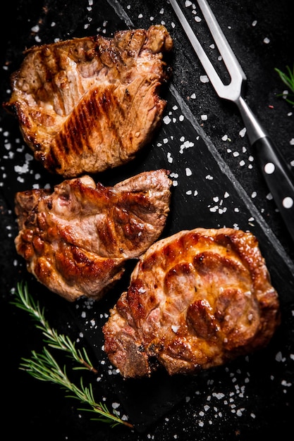 Photo grilled pork steak with a sprig of rosemary