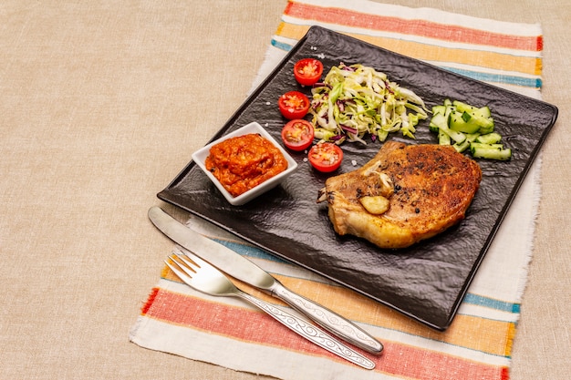 Grilled pork steak with tomato sauce and coleslaw salad