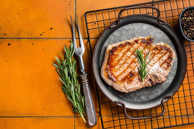 Foto carne di maiale alla griglia t carne tagliata a ossa steak sfondo arancione vista superiore spazio di copia