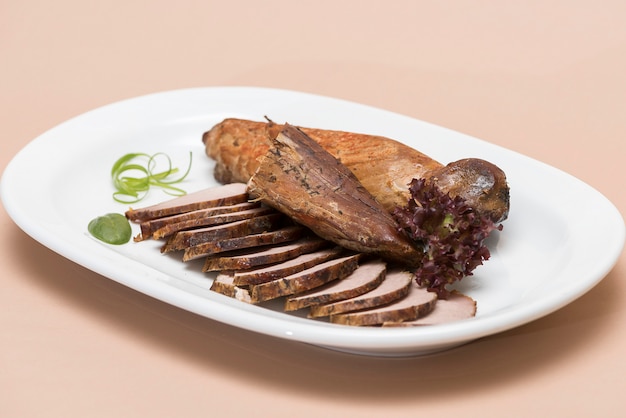 Grilled pork tenderloin, decorated with green leaf