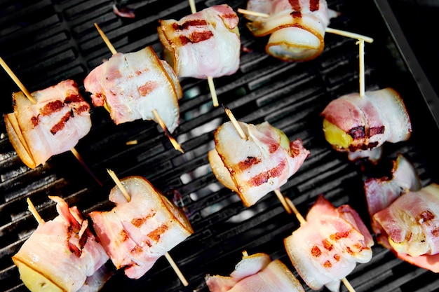 Grilled potato with bacon on gas grill .