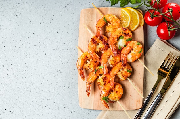 Grilled prawns on wooden skewers, shrimp kebab. Top view, free space for text. High quality photo