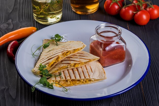 Grilled quesadillas on black wooden background