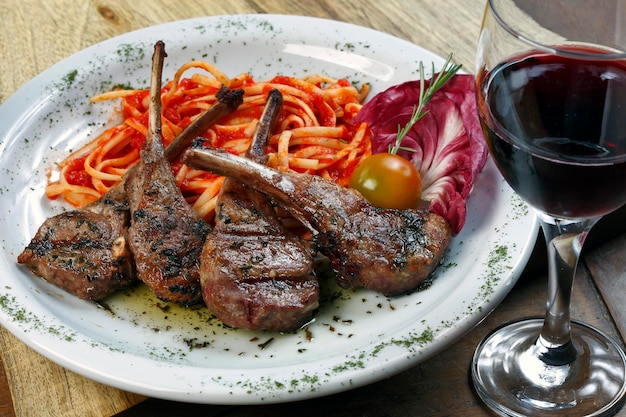 Grilled rack of lamb with pasta and a glass of red wine