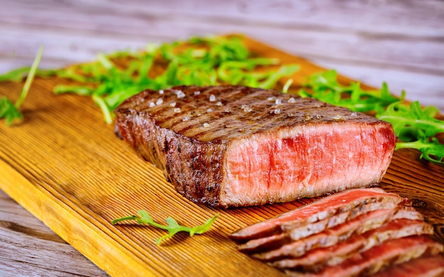 Grilled rare angus beef steak on wooden board