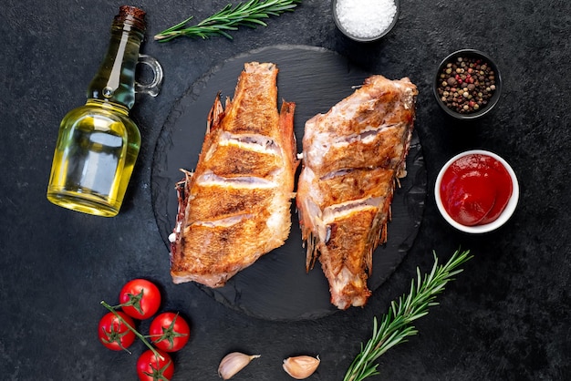 grilled red sea bass with rosemary and spices on a stone background