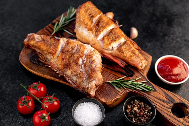 grilled red sea bass with rosemary and spices on a stone background