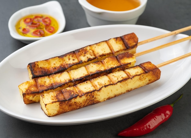 Grilled Rennet or Coalho cheese on a plate with sugar syrup and pepper