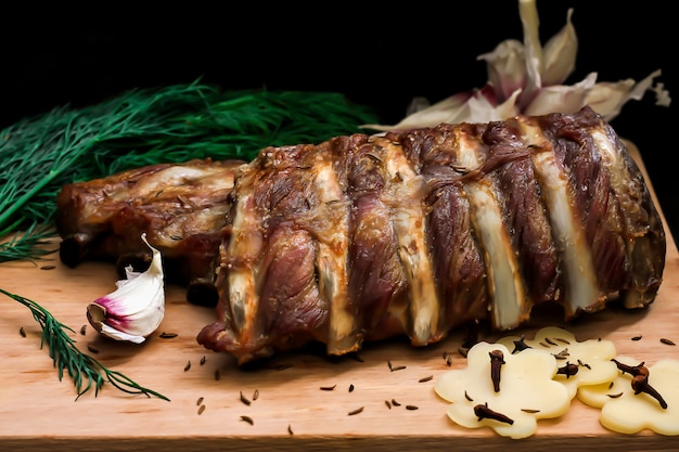 Жареное мясо ребра с чесноком и зеленью на деревянной доске
