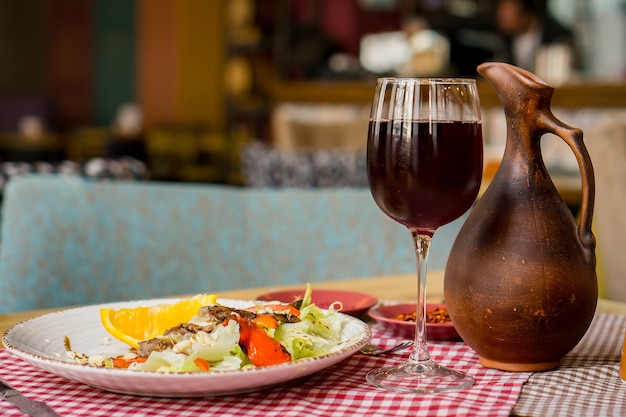 Grilled ribeye beef steak with red wine, herbs and spices on wooden table