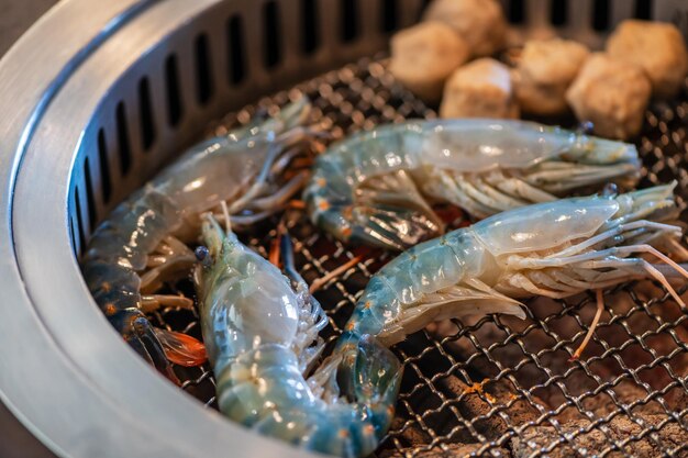 Photo grilled river prawns on a hot charcoal grill grilled prawns