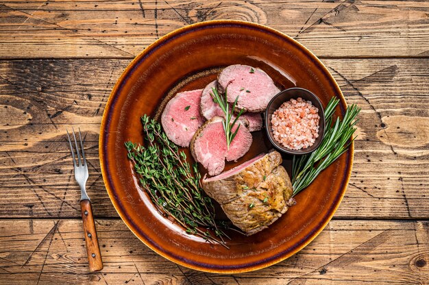 Grilled Roast beef fillet meat on a rustic plate with salt.