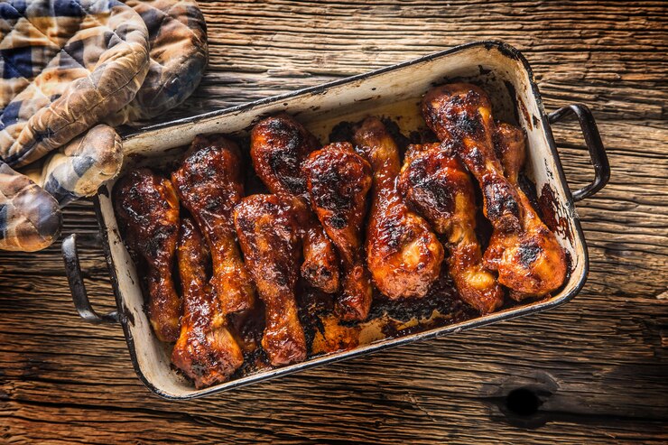 Photo grilled roasted and barbecue chicken legs in pan.