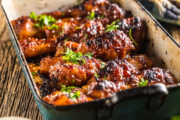 Grilled roasted and barbecue chicken legs in pan.