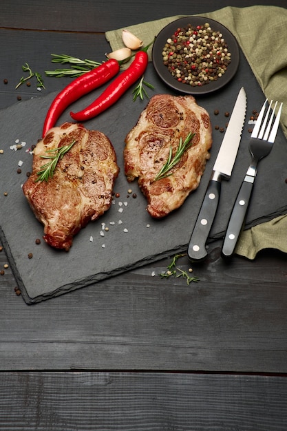 Grilled roated beef steaks on stone serving cutting board