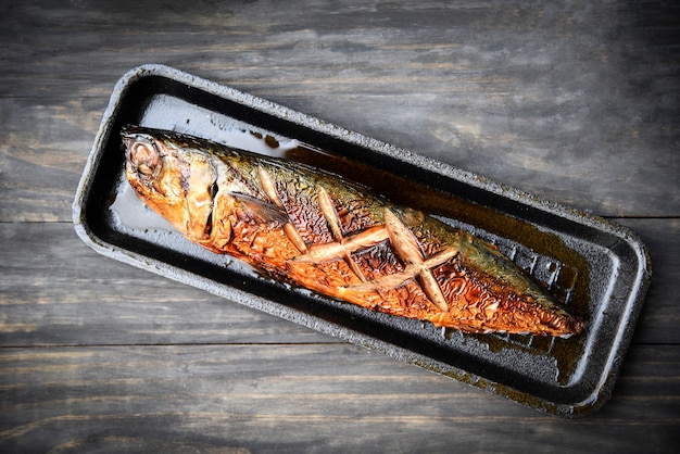 Grilled saba fish with sweet sauce on tray with dark  