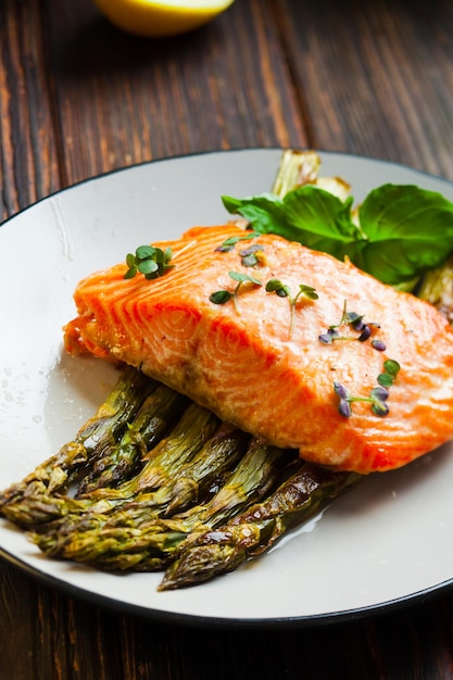 Grilled salmon fillet on the asparagus on white plate, dinner in the restourant