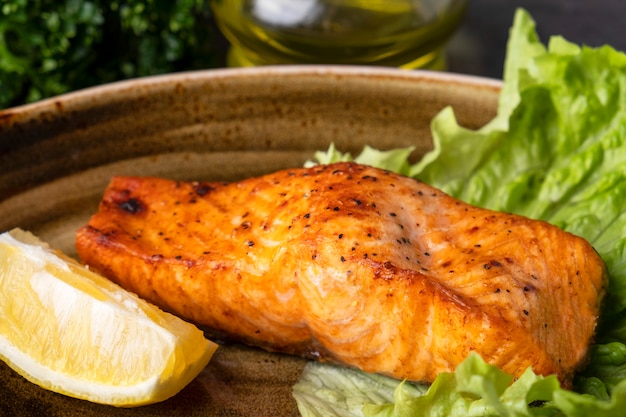 grilled salmon fillet  piece of lemon on a plate. closeup