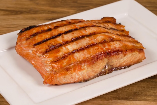 Grilled salmon fillet served on a white plate