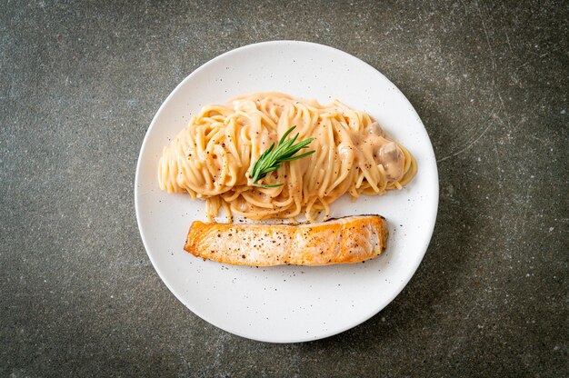 Foto filetto di salmone alla griglia con salsa di pomodoro cremoso di spaghetti