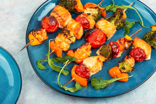 Grilled salmon fish kebab skewers with vegetables