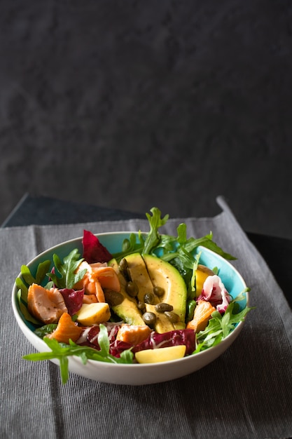 Grilled salmon salad with avocado, arugula