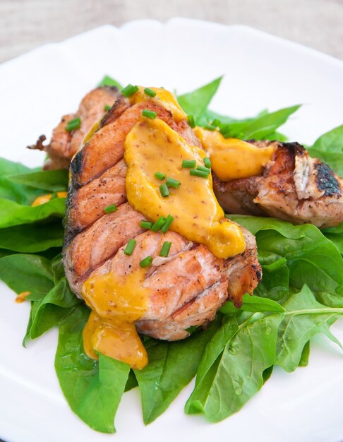 Salmone grigliato su cuscino di spinaci con salsa all'arancia e senape