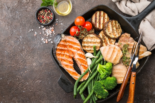 Grilled salmon steak, chicken and vegetables