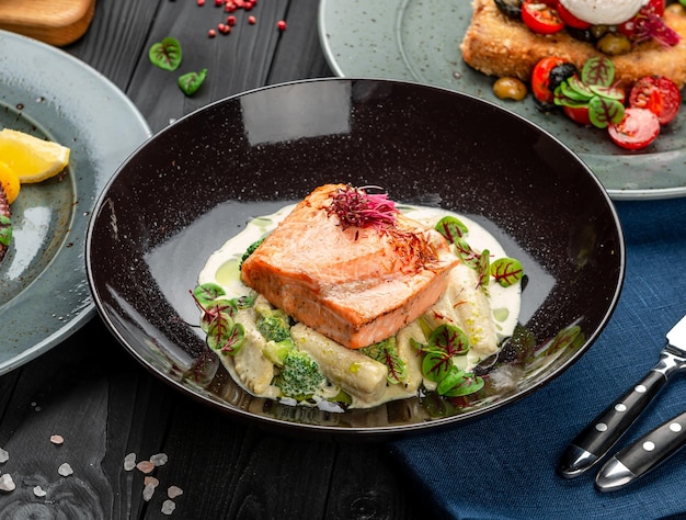 grilled salmon steak in a creamy sauce on small ears of corn