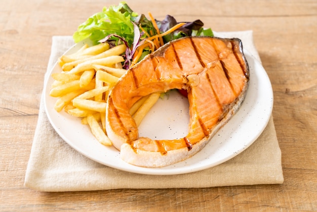 サーモンステーキフィレ肉のグリルと野菜とフライドポテト