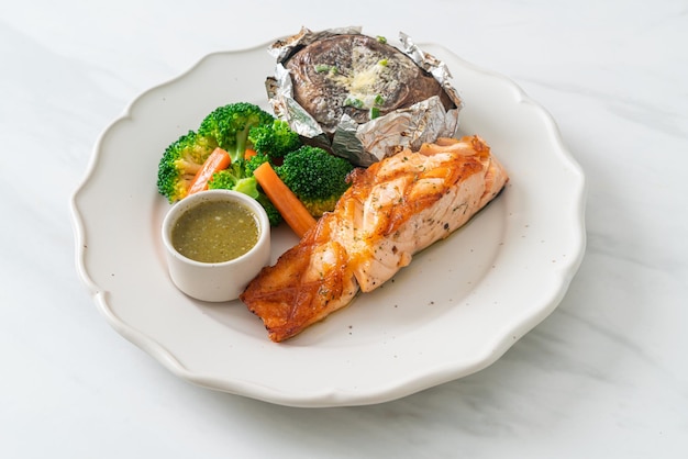 grilled salmon steak with bake potato and vegetables