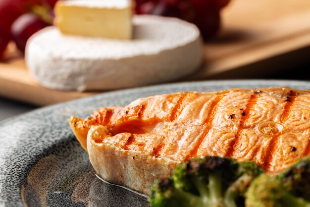 Grilled salmon steak with broccoli on grey plate