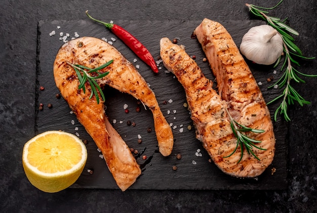 Grilled salmon steaks with spices on stone table